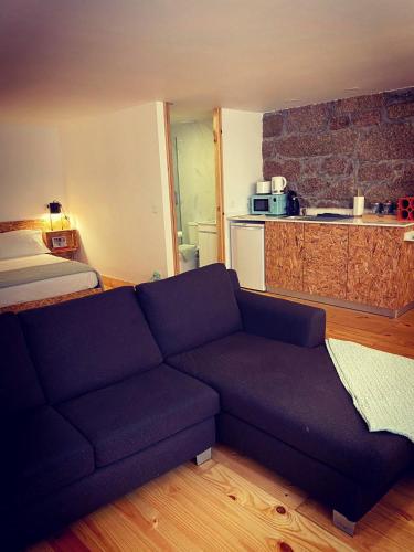 a living room with a couch and a kitchen at Viela alojamentos Amarante in Amarante
