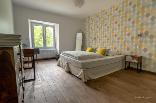 a bedroom with a bed with yellow pillows at Le Manoir, appartement Onyx in Le Bourg-dʼOisans