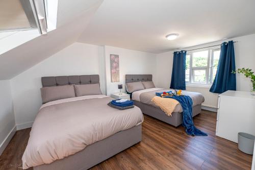 a bedroom with two beds and a couch at 4 bedrooms,2 bathrooms house with free parking in Plumstead