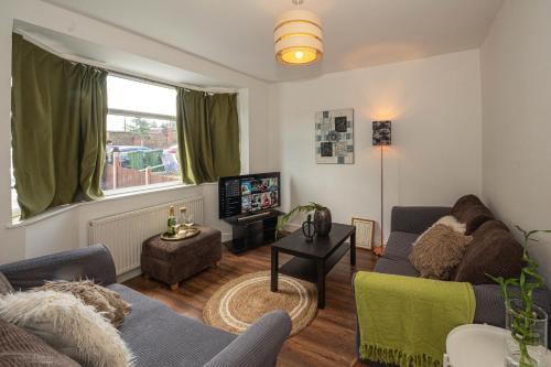 uma sala de estar com um sofá e uma televisão em 4 bedrooms,2 bathrooms house with free parking em Plumstead