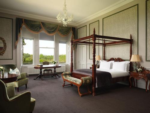a bedroom with a canopy bed and a table and chairs at Lyrath Estate in Kilkenny