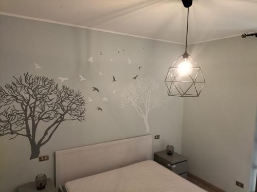 una camera da letto con letto e alberi sul muro di Casa Rina a Nesso