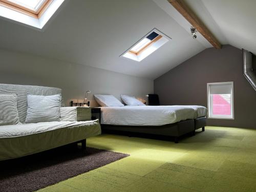 a bedroom with two beds and a couch at Texelheerlijk 4 in De Koog