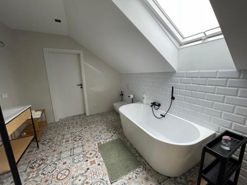 a large white bath tub in a bathroom with a window at Dwa Żurawie - Głuszyn in Głuszyn
