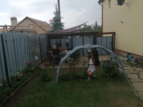 a woman is standing in a backyard with a gazebo at Apartman Lastovicka in Stará Lesná