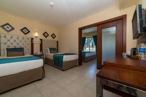 a hotel room with two beds and a desk at Kamelya Aishen Club & Aqua Ultra All Inclusive Kids Concept in Side