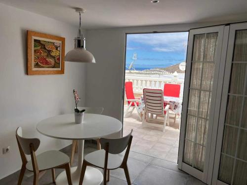 ein Esszimmer mit einem Tisch und Stühlen sowie einem Balkon in der Unterkunft Casa lele en anfi del mar in Los Caideros