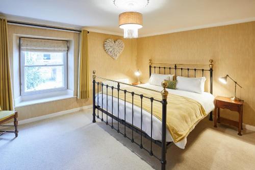 a bedroom with a large bed and a window at Host & Stay - Sixpence Cottage in Pickering
