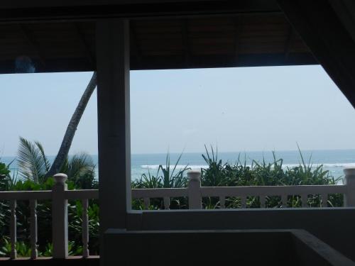 a view of the ocean from the porch of a house at Haus am Meer "Wilde Ananas" in Koggala