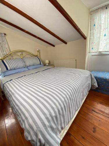 a bedroom with a bed with a striped comforter at The Coach House By The Sea in Mablethorpe