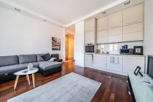 a living room with a couch and a kitchen at Rynek 45 Apartament in Wrocław