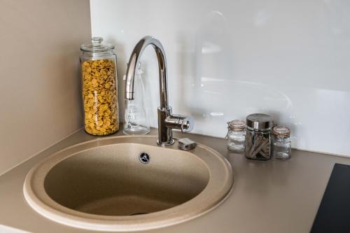 a kitchen counter with a sink with a jar of food at Rynek 45 Apartament in Wrocław