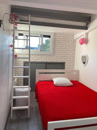 - une chambre avec un lit rouge et une échelle dans l'établissement T2 Cabourg - Résidence Le Sporting, à Cabourg