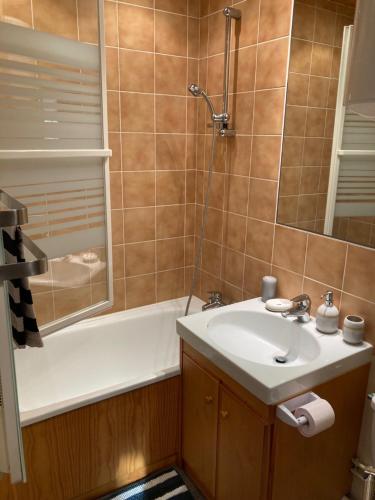 une salle de bain avec un lavabo et une baignoire dans l'établissement T2 Cabourg - Résidence Le Sporting, à Cabourg