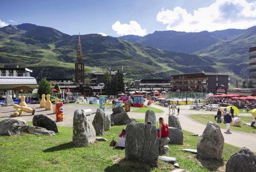 un groupe de personnes debout autour de rochers dans un parc dans l'établissement Belambra Clubs Les Menuires - Neige Et Ciel, aux Menuires