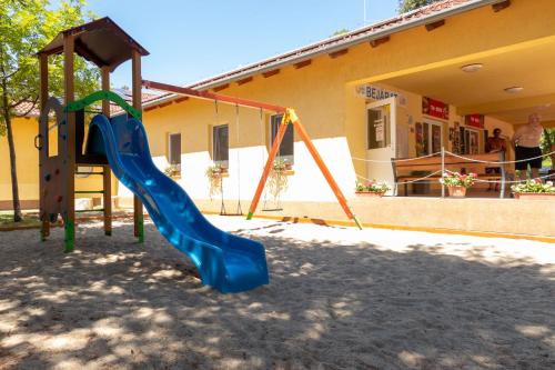 a playground with a slide in front of a building at Hotel Imperial Gyogyszallo es Gyogyfurdo in Kiskőrös