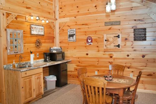 a dining room with a table and a kitchen in a cabin at 7Cs lodging in Flintstone