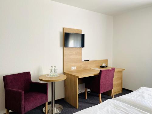 a hotel room with a desk and two chairs at Hotel Esmer in Lollar