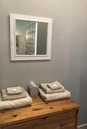 - un miroir installé au-dessus d'une commode en bois avec des serviettes dans l'établissement La Verrerie de Guerlédan, à Caurel