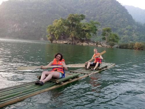 two women are sitting on a raft in the water at Ba Be Lake View Homestay in An Ma