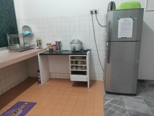 uma pequena cozinha com um frigorífico e uma mesa em CORNER LOT,LANDED Kajang Semenyih Bee Homestay em Semenyih