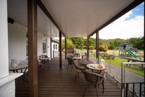 a porch with tables and chairs and a playground at Entire Venue Hire with 8 Bedroom Accommodation - Your Own Pub Experience in Swansea