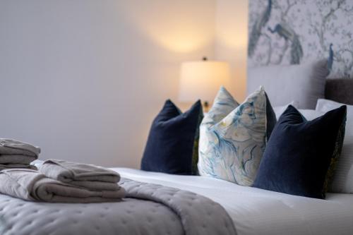 a bedroom with a bed with blue pillows at Entire Venue Hire with 8 Bedroom Accommodation - Your Own Pub Experience in Swansea