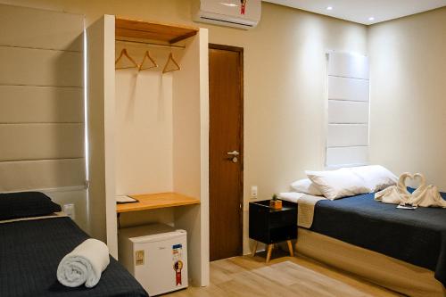 a small room with two beds and a closet at Pousada Sete Mares in Maragogi