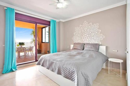 a bedroom with a bed and a balcony with a table at Estrella de Mar zeezicht en uitkijk op Gibraltar 40m2 terras incl zwembad Las Garzas Manilva in Manilva