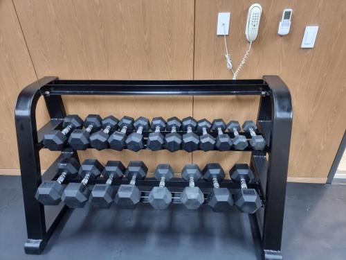 a rack of dumbbells in front of a door at Hotel bridge Seogwipo in Seogwipo