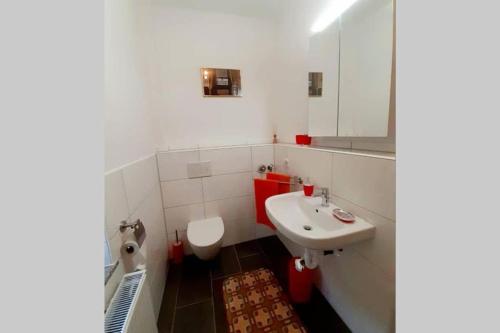 a white bathroom with a sink and a toilet at FeWo Weser in Hadamar