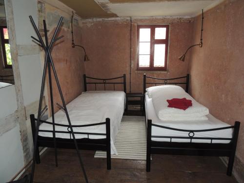a small room with two beds and a window at Pilger- und Radlerherberge Herberge im Hofhaus in Colmberg
