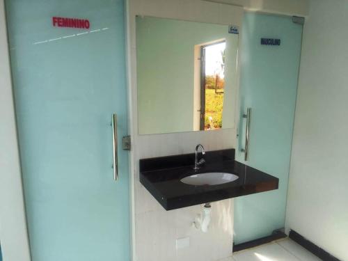 bagno con lavandino nero e specchio di Pousada Peruaçu & Restaurante a Fabião