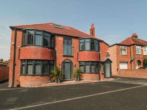 a red brick house with plants in front of it at Nightingales in Bridlington