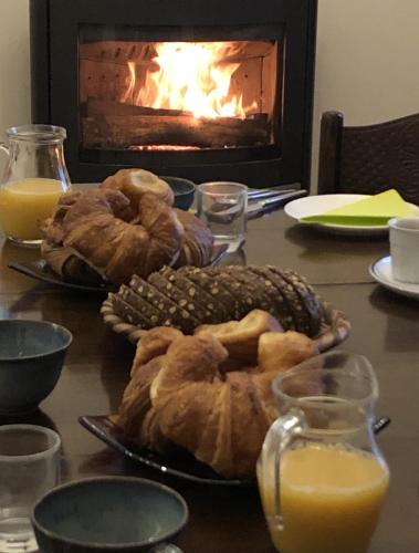 une table avec des assiettes de pâtisseries et une cheminée dans l'établissement La Verrerie de Guerlédan, à Caurel