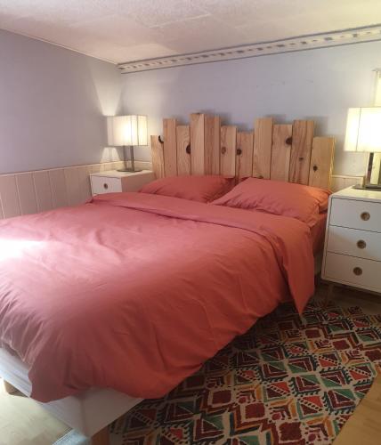 - une chambre avec un grand lit et des draps rouges dans l'établissement Maison bord de Marne 8min disneyland et val d'Europe, à Chalifert