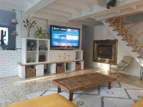 un soggiorno con una TV a grande schermo e un tavolino da caffè di Maison bord de Marne 8min disneyland et val d'Europe a Chalifert