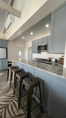 a kitchen with a row of stools and a counter at Stonetrail in Arnos Vale