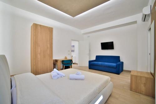1 dormitorio con 1 cama y 1 sofá azul en La Morada Leverano, en Leverano
