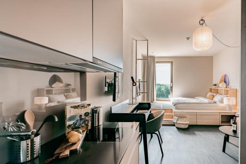 Ariv Apartments & Spaces - self check-in في بازل: غرفة معيشة مع مكتب وغرفة نوم