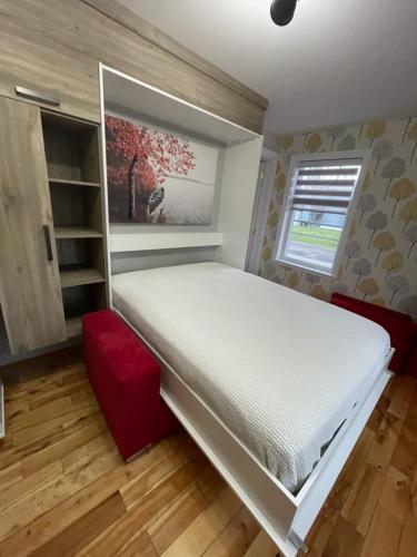 a bedroom with a large white bed and a window at Hôtel les quatre bonheurs in Amqui