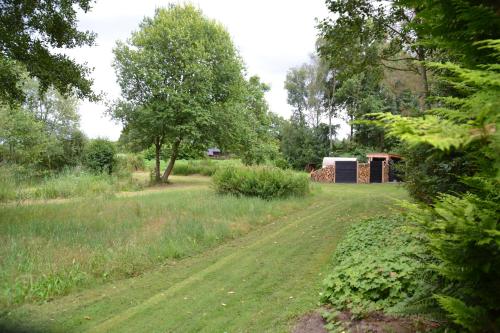 a dirt road in a field with trees and a building at kemphaan in Appelscha