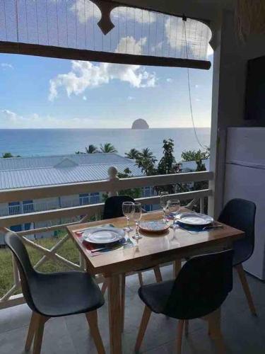 a table and chairs with a view of the ocean at Bohème créole in Le Diamant