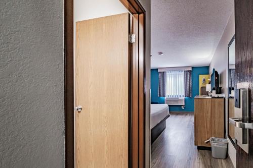 a room with a room with a bed and a door at Days Inn by Wyndham Brunswick Bath Area in Brunswick