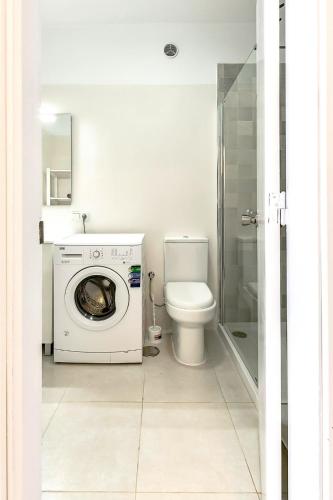 a bathroom with a washing machine and a toilet at Sweet View Study - Playa Paraiso Tenerife in Adeje