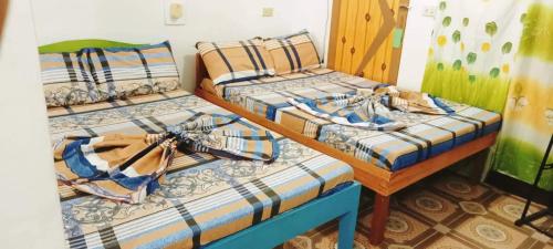 two twin beds in a room with at Dreamland Nilo Eve Beach Guest Huaz in El Nido