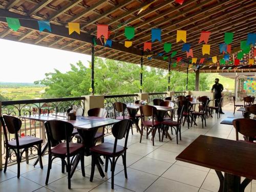 ein Restaurant mit Tischen und Stühlen auf einer Terrasse in der Unterkunft Gravatá Flat no condomínio Monte Castelo MELHOR LOCALIZAÇÃO , Wi-Fi, SKY e AR in Gravatá