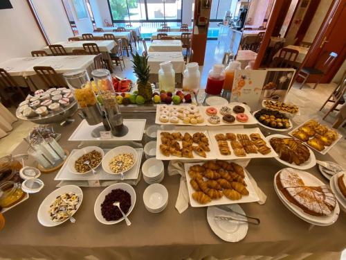 a table with many plates of food on it at Hotel Nettunia in Rimini