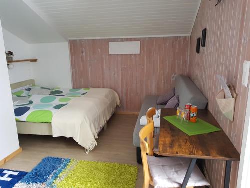 a small bedroom with a bed and a table and a table sidx sidx at Tattoo PENSION mit Restaurant und Tattoo-Studio in Mörtschach