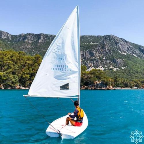 a man sitting on a sail boat in the water at Yucelen Hotel in Akyaka